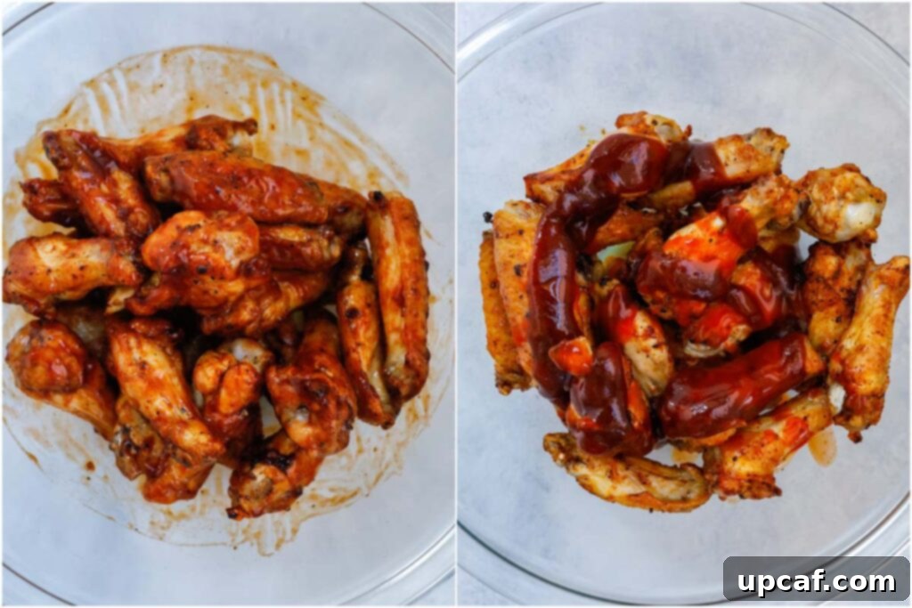 Coated air-fried chicken wings being tossed in a bowl with a glossy BBQ sauce, ready for serving.