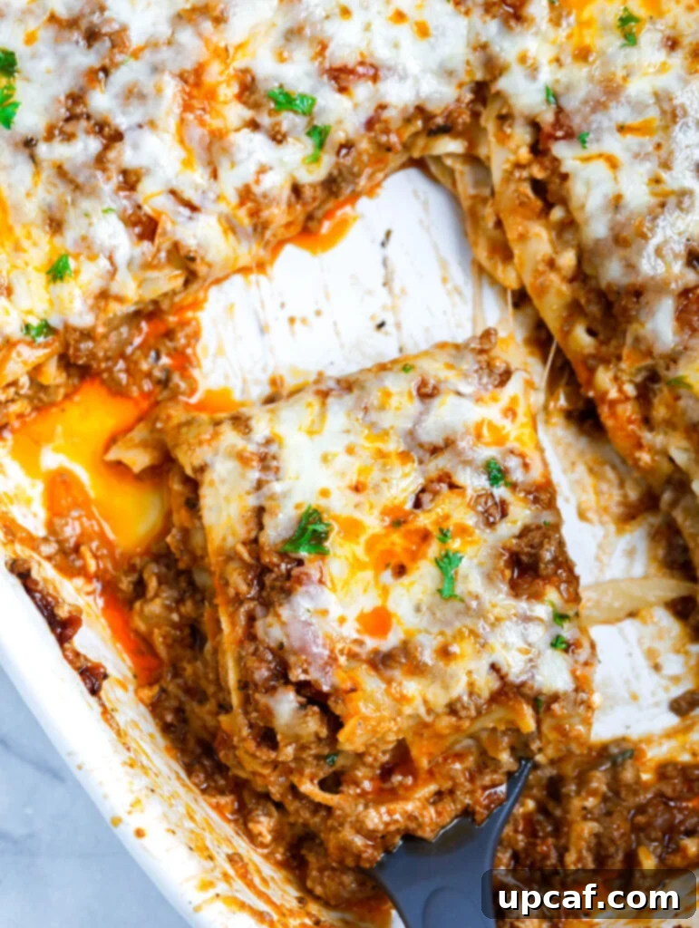 A delectable slice of homemade Meat Lasagna being lifted from a baking dish with a spatula, showcasing its layers of pasta, rich meat sauce, and melted cheese.